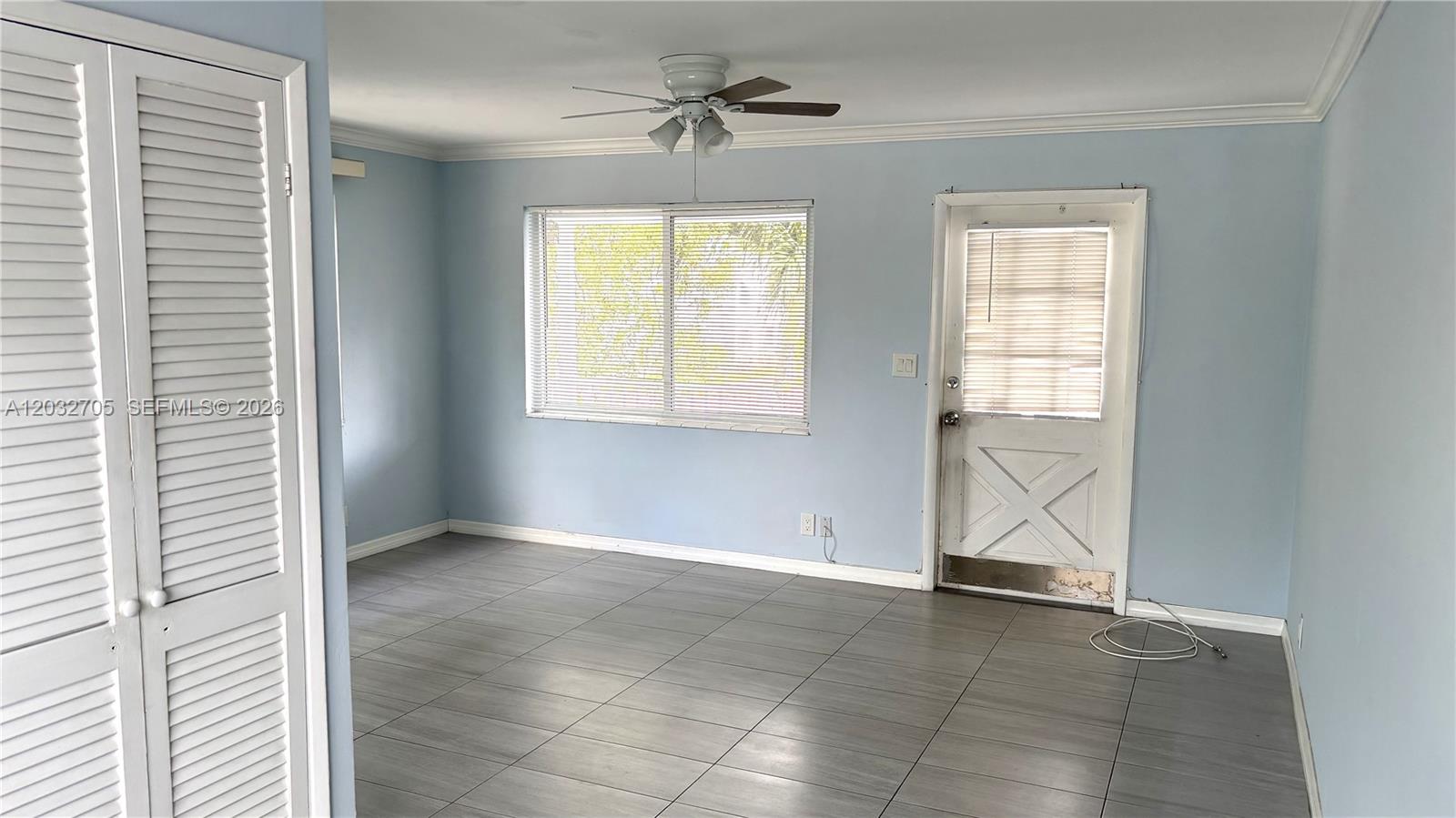 A white two-story apartment building features exterior staircases and lush landscaping in the foreground — 601 S 19th Ave # 10, Hollywood FL 33020, HOLLYWOOD, FL