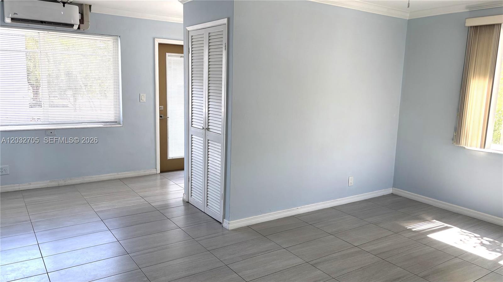 A room with light blue walls, gray tile flooring, two windows, and a ceiling fan — 601 S 19th Ave # 10, Hollywood FL 33020, HOLLYWOOD, FL