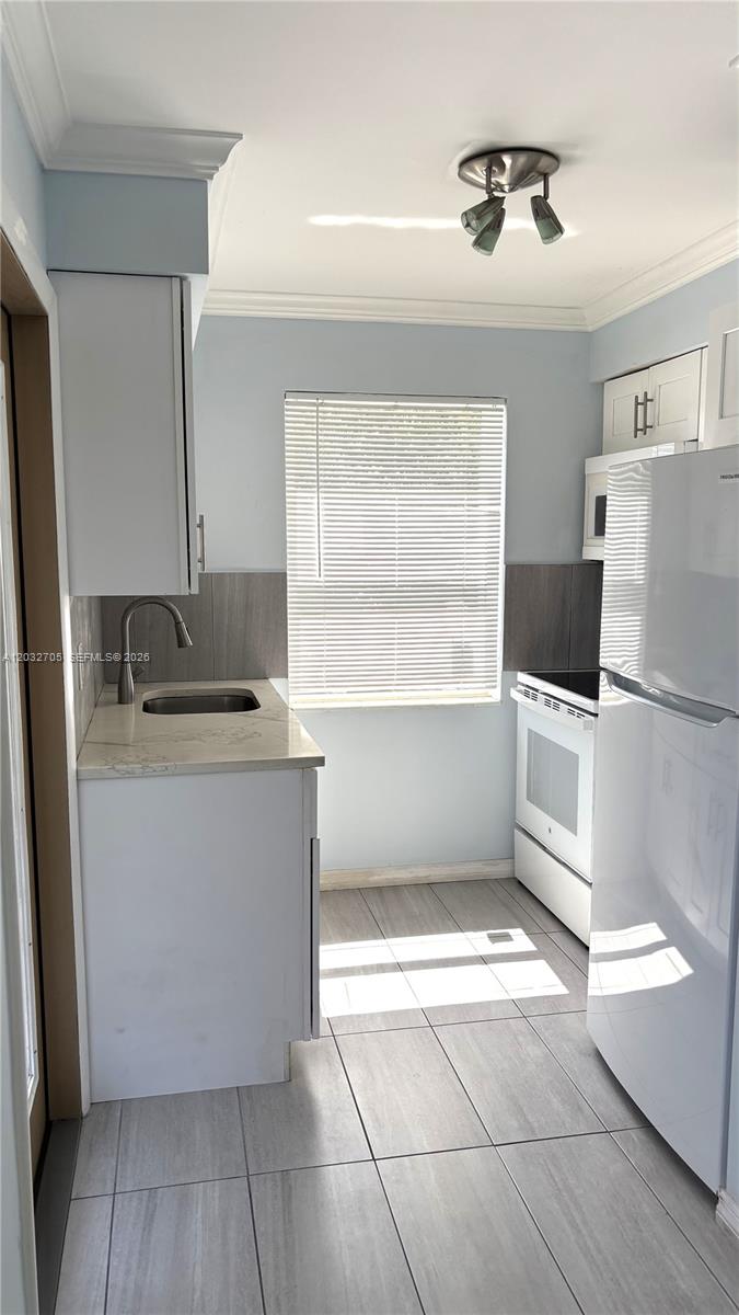 An empty room features light blue walls, grey tiled flooring, and a white louvered closet — 601 S 19th Ave # 10, Hollywood FL 33020, HOLLYWOOD, FL