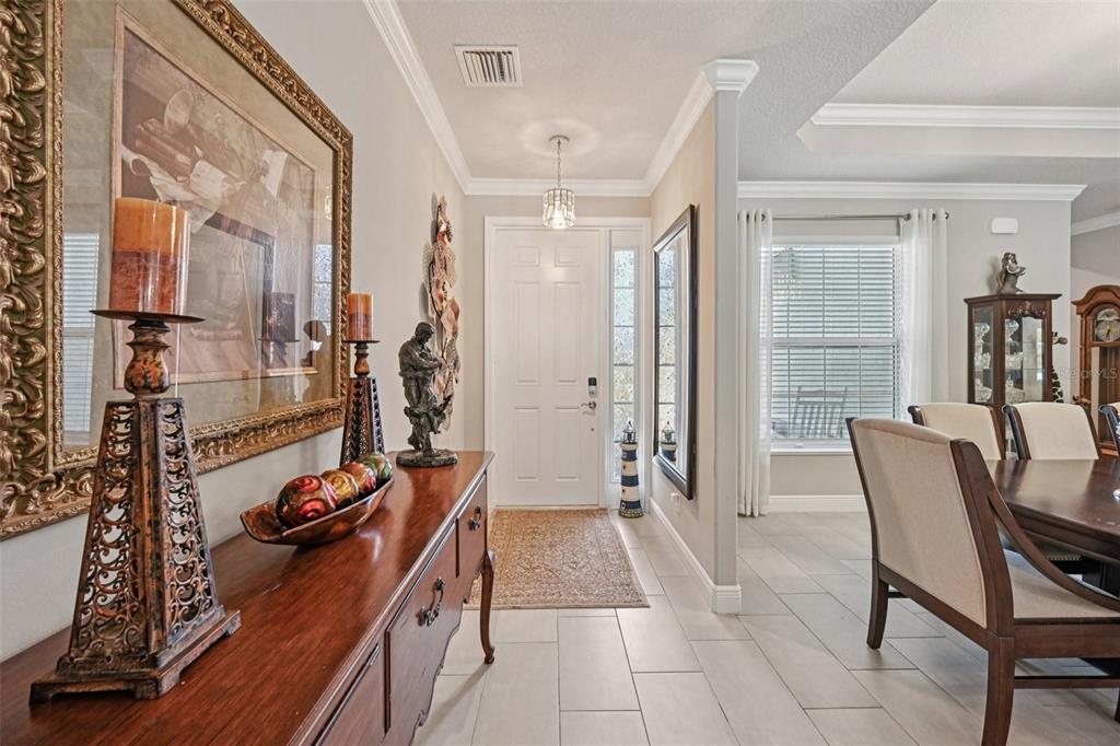 A foyer with a wooden console table leads to a dining area with tiled floors — 3955 OAK HOLLOW AVENUE, VERO BEACH, FL