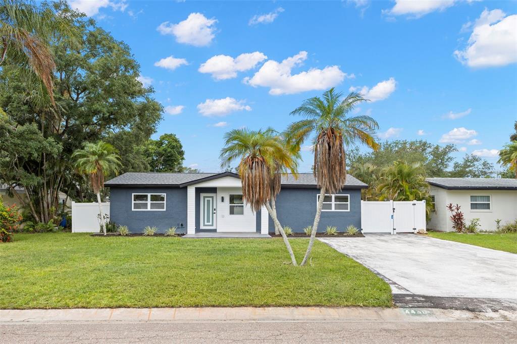 An aerial view shows a blue single-story house with a white front door and driveway — 4430 CARSON STREET NE, ST PETERSBURG, FL