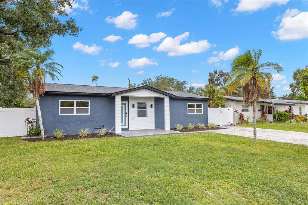 A blue single-story house with a white front door and palm trees in the yard — 4430 CARSON STREET NE, ST PETERSBURG, FL