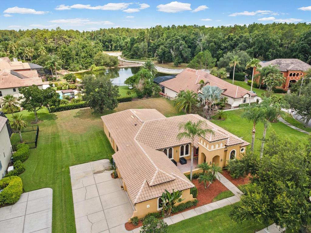 An aerial view shows a tan stucco house with a tiled roof and a pool — 3708 MARBURY COURT, LAND O LAKES, FL