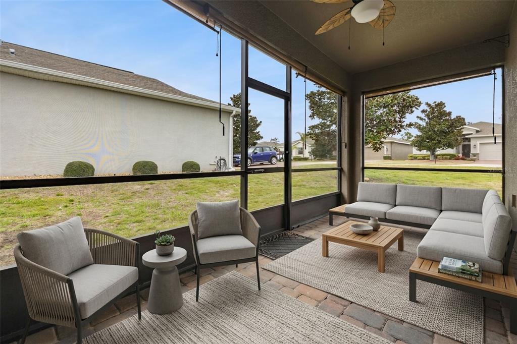 A living room features light blue sofas, a white coffee table, and two rattan chairs — 3464 EMBERS LANE, CLERMONT, FL