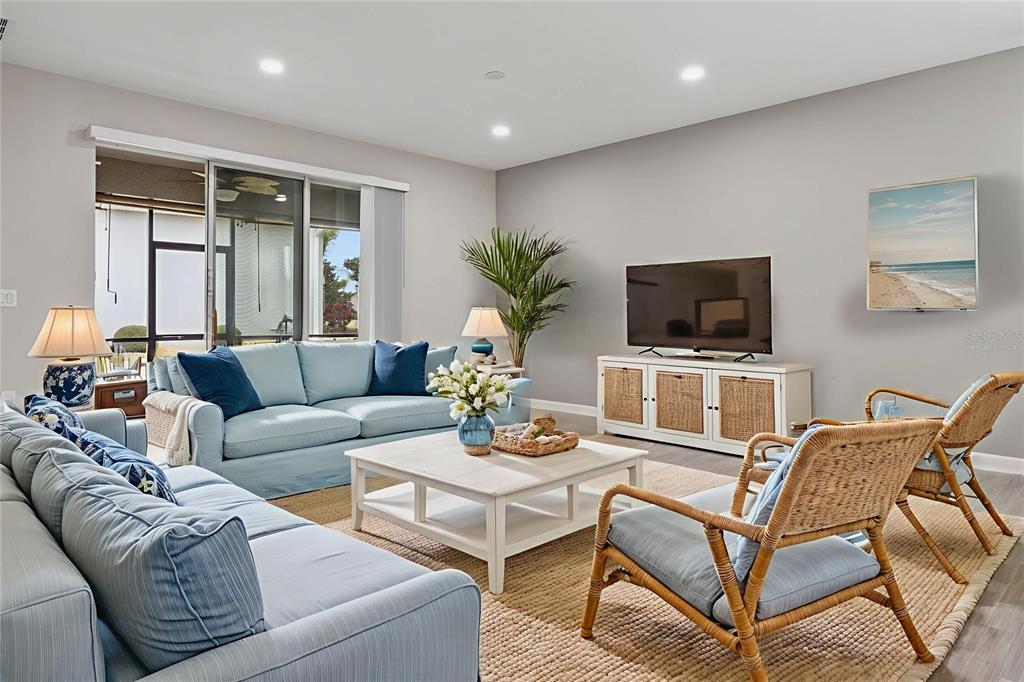 A dining room features a white table, six blue patterned chairs, and a coastal painting — 3464 EMBERS LANE, CLERMONT, FL