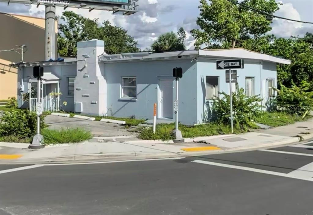 A light blue, single-story commercial building sits on a corner lot near a street intersection — 904 7TH AVENUE E, BRADENTON, FL