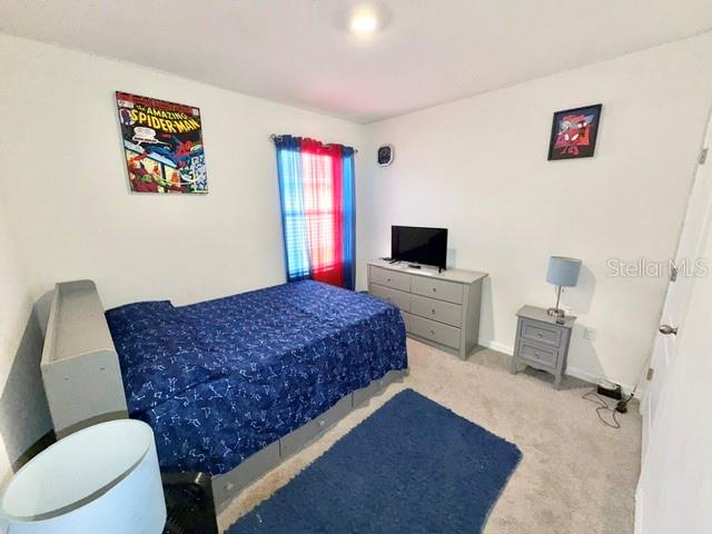 A bedroom features a bed with a blue patterned comforter, a dresser, and Spider-Man decor — 3728 ALDER BARK LANE, SANFORD, FL