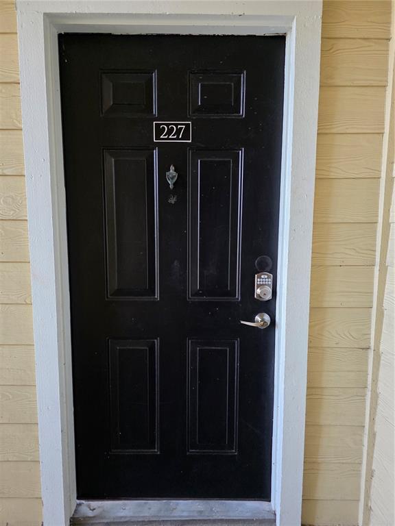 A black front door with a digital keypad lock and the number 227 displayed above — 2648 ROBERT TRENT JONES DRIVE UNIT 227, ORLANDO, FL