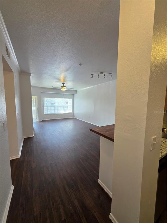 An open-concept living area features dark wood-look flooring, white walls, and a ceiling fan — 2648 ROBERT TRENT JONES DRIVE UNIT 227, ORLANDO, FL