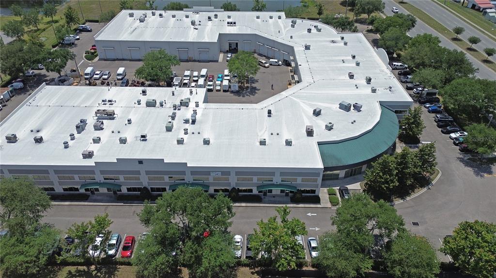 An aerial view shows a large commercial building with a white roof and parking lots — 10501 S ORANGE AVENUE UNIT 107, ORLANDO, FL
