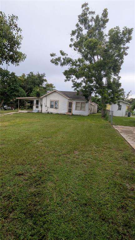 A white single-story house with a large tree in the front yard — 1102 W 13TH STREET, LAKELAND, FL