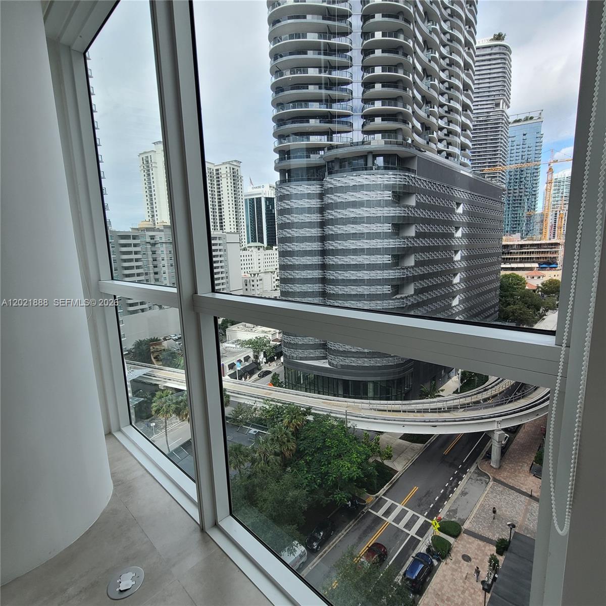 A view of a city street and high-rise buildings from a modern apartment window — 1080 Brickell Ave # 1101, Miami FL 33131, MIAMI, FL