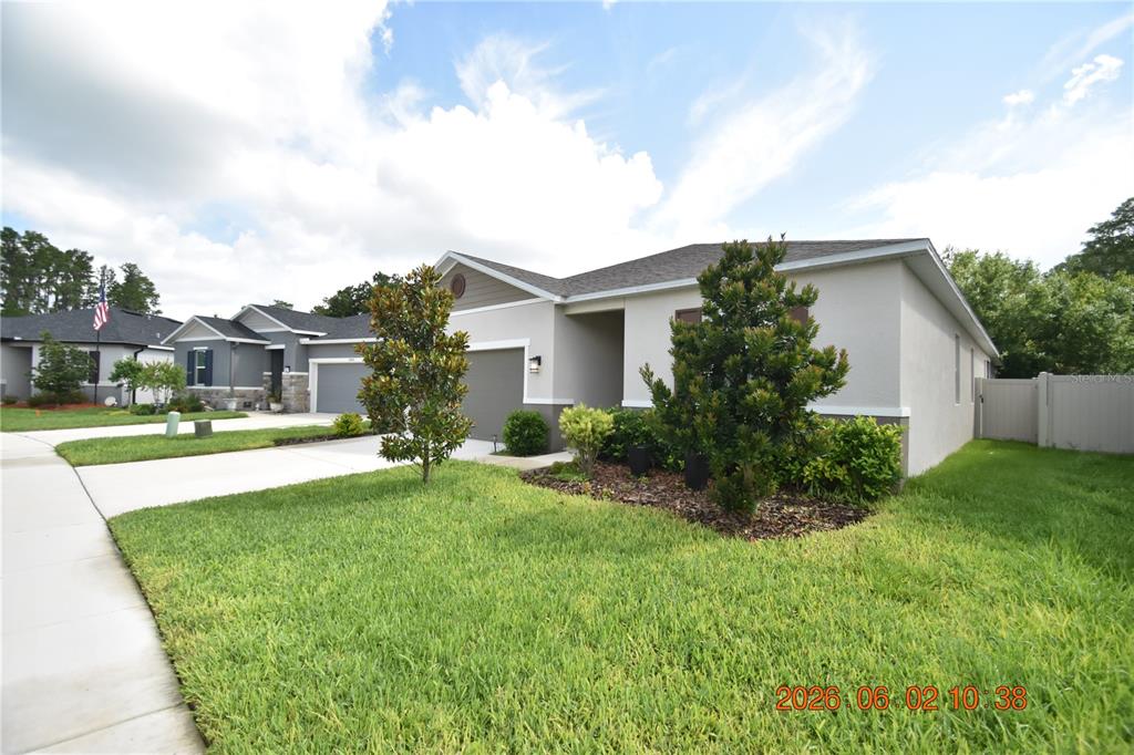 A single-story suburban house with a gray exterior, a two-car garage, and a landscaped lawn — 20076 AZUL MARBLE LOOP, LAND O LAKES, FL