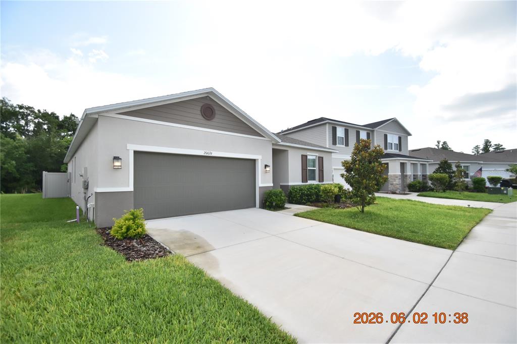 A single-story house with a gray garage door and a concrete driveway — 20076 AZUL MARBLE LOOP, LAND O LAKES, FL