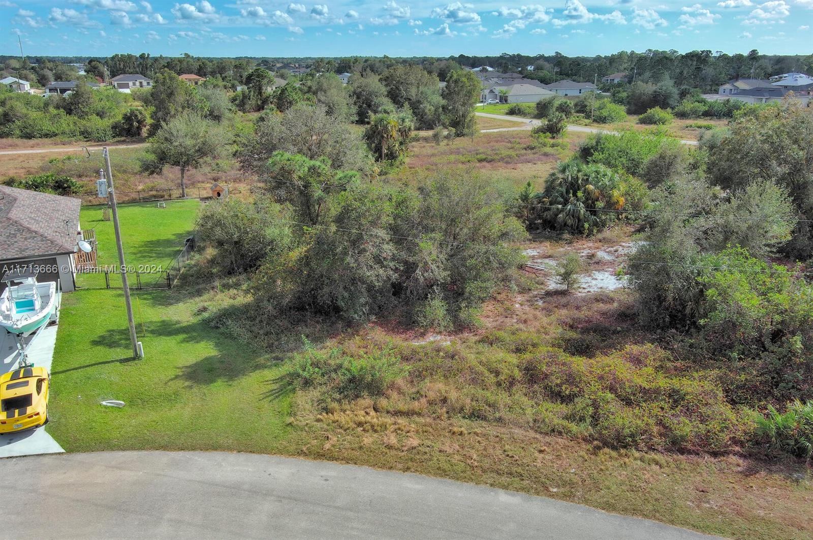 An aerial view shows a residential lot with a house, a boat, and a car — 309 Raber Ave, Lehigh Acres FL 33974, LEHIGH ACRES, FL
