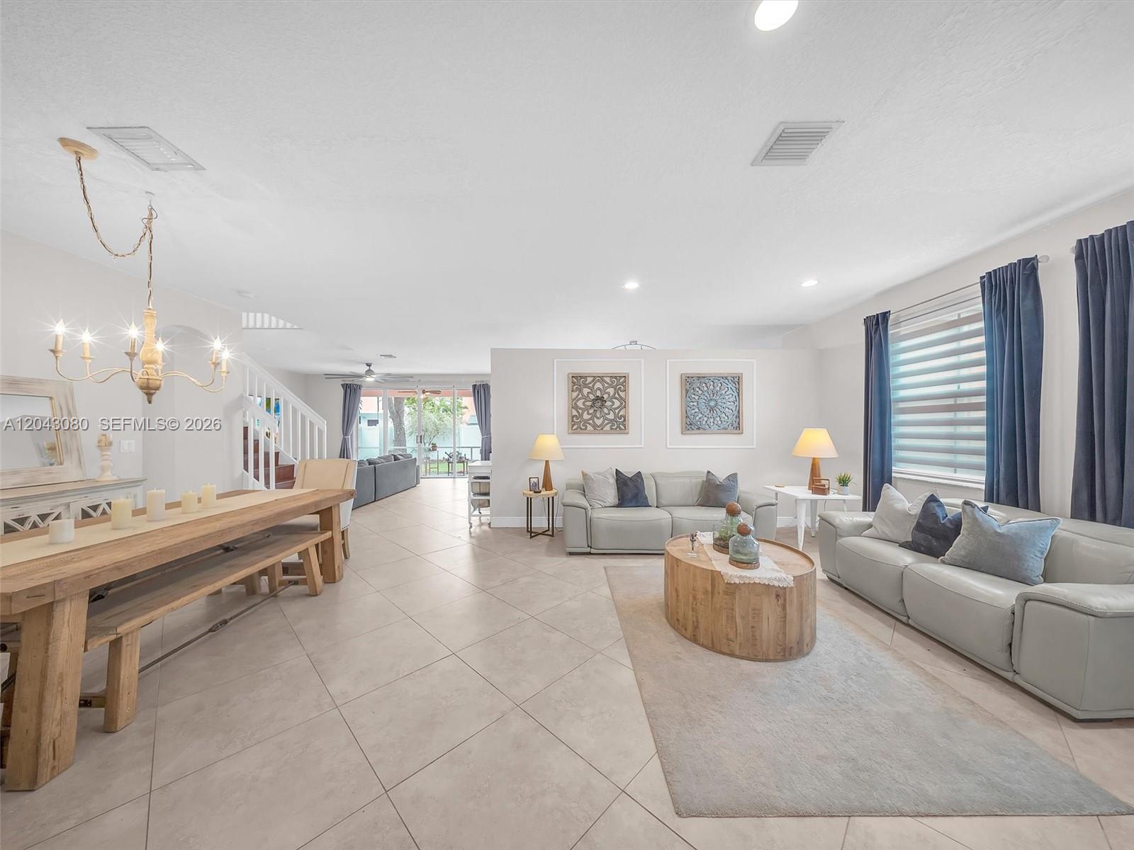 An open-concept living and dining area features tile floors, a wooden table, and leather sofas — 4907 SW 166th Ave, Miramar FL 33027, MIRAMAR, FL