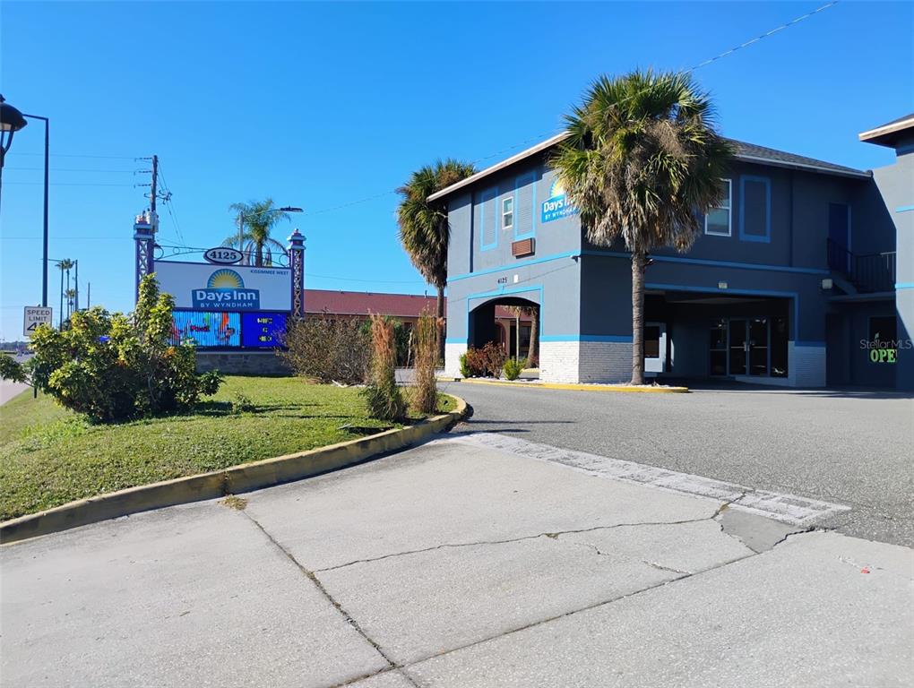 A Days Inn hotel building with a parking lot and a large roadside sign — 4125 W VINE STREET, KISSIMMEE, FL