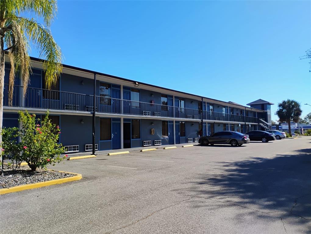 A two-story motel building with a blue exterior, exterior walkways, and a paved parking lot — 4125 W VINE STREET, KISSIMMEE, FL