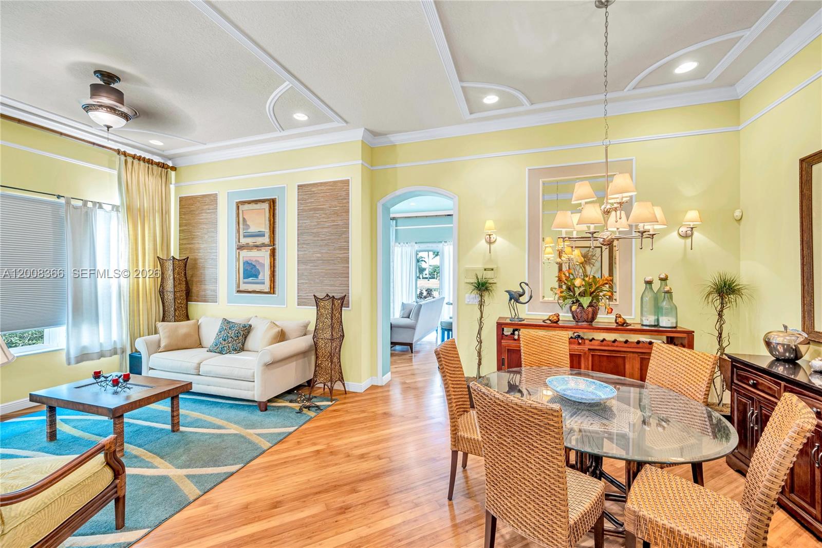 A living and dining area features yellow walls, hardwood floors, and a glass-topped table — 3465 NE 2nd St, Homestead FL 33033, HOMESTEAD, FL