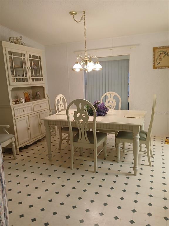 A dining room features a white hutch, a matching table with chairs, and patterned flooring — 5415 JACOB AVENUE, POLK CITY, FL