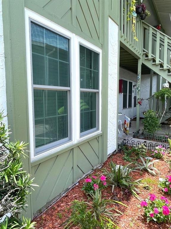 A green-trimmed exterior wall features two windows and a staircase leading to an upper level — 840 CENTER AVENUE UNIT 67, HOLLY HILL, FL