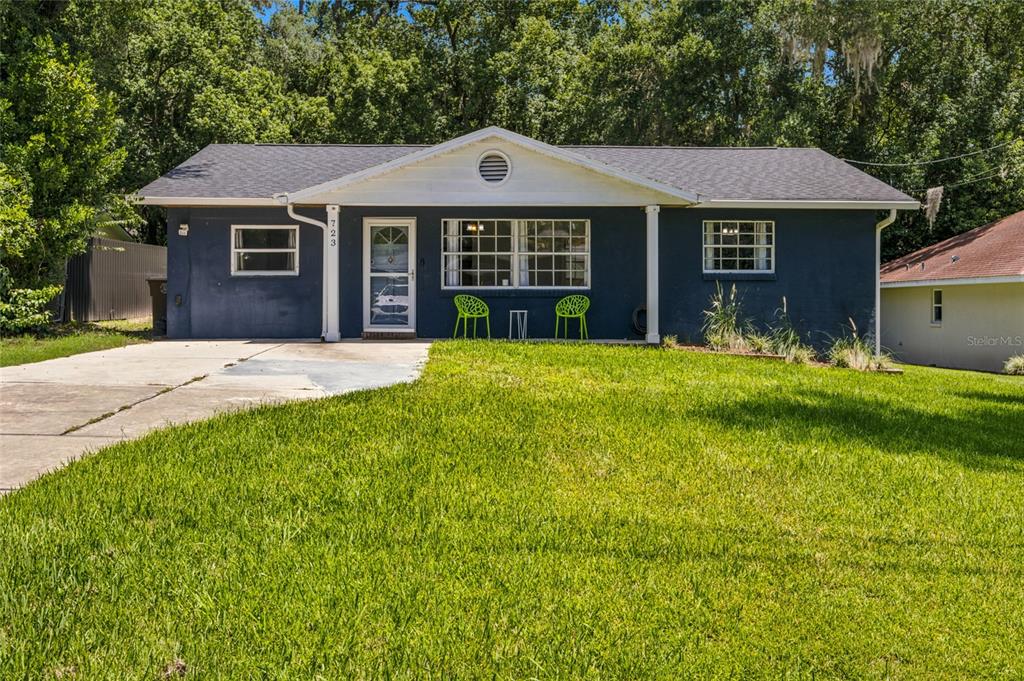A blue, single-story house with a white trim, a front porch, and a grassy lawn — 723 SE 30TH AVENUE, OCALA, FL