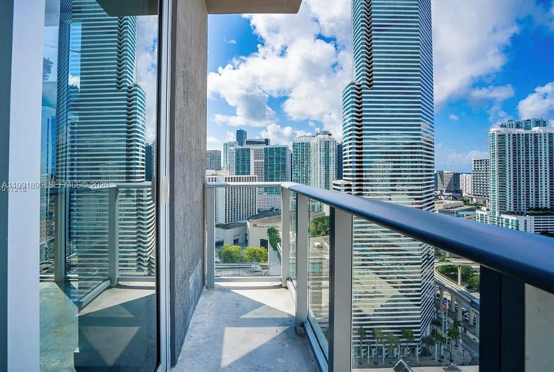 A high-rise balcony overlooks a dense urban cityscape with multiple glass skyscrapers — 151 SE 1st St # 2411, Miami FL 33131, MIAMI, FL