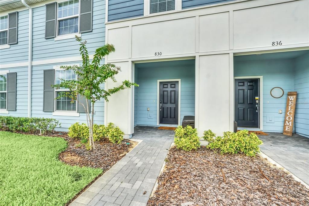 The exterior of a two-story blue building features two black front doors and walkways — 830 PARADISE DRIVE, DAVENPORT, FL