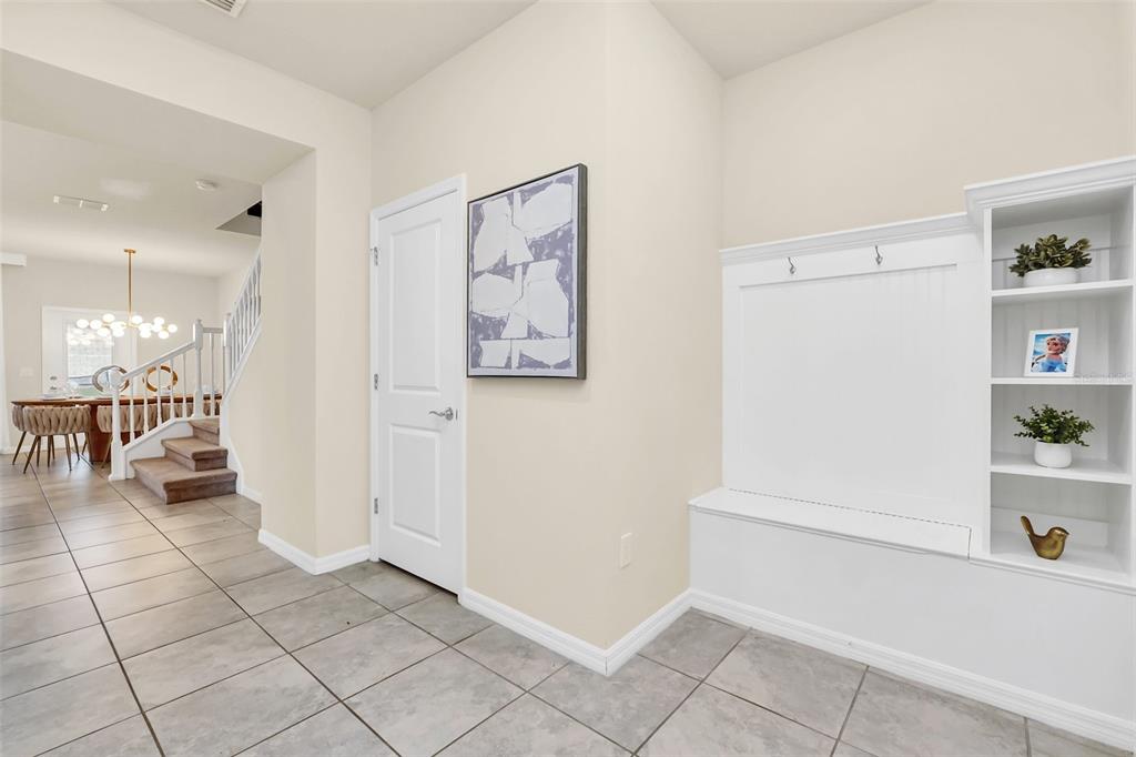 A tiled entryway features a white built-in bench with shelving and a closed interior door — 830 PARADISE DRIVE, DAVENPORT, FL