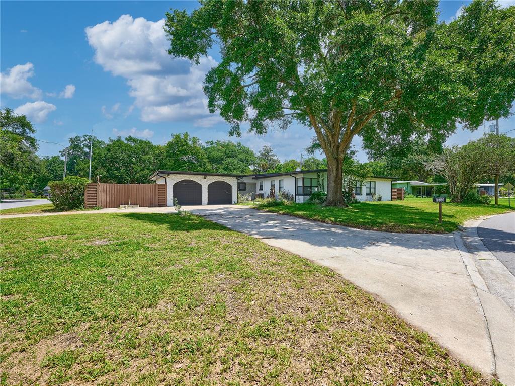 A single-story house with a two-car garage and a large tree in the front yard — 1100 CORNELL DRIVE, SANFORD, FL