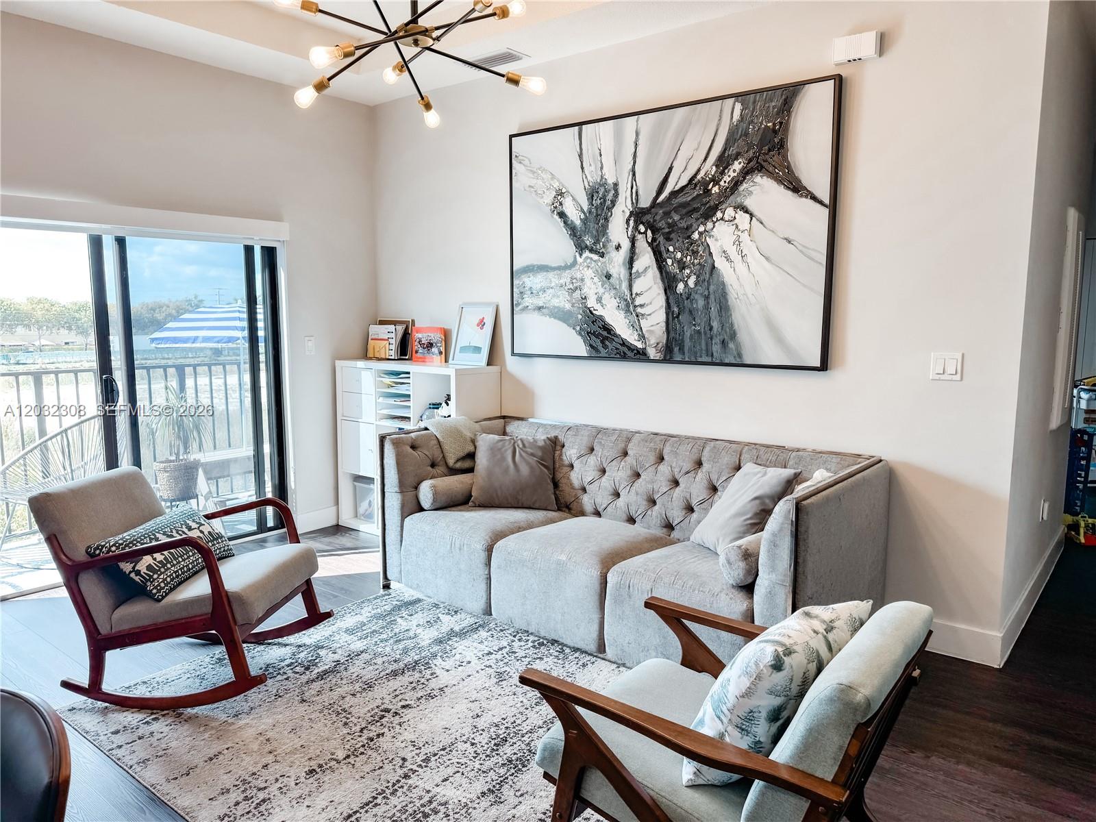 A living room features a tufted gray sofa, two armchairs, and a large abstract painting — 10455 NW 82nd St # 32, Doral FL 33178, DORAL, FL