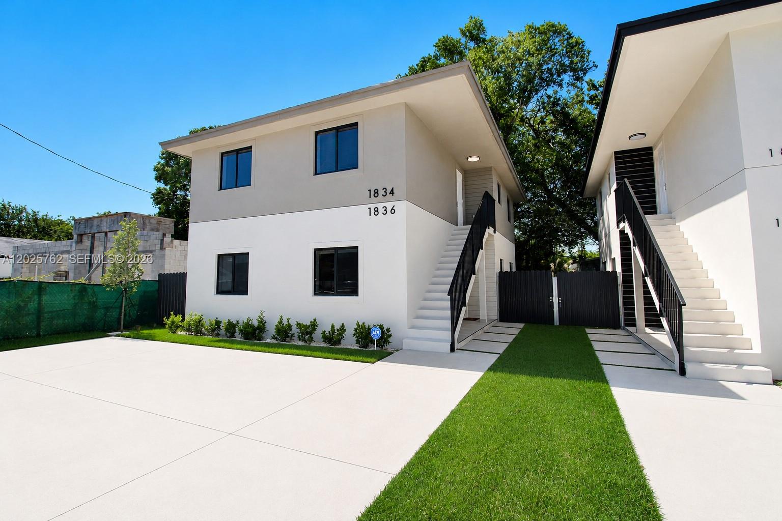 Two modern two-story residential buildings feature white and gray exteriors with external staircases — 1834 NW 63rd St # 1834, Miami FL 33147, MIAMI, FL