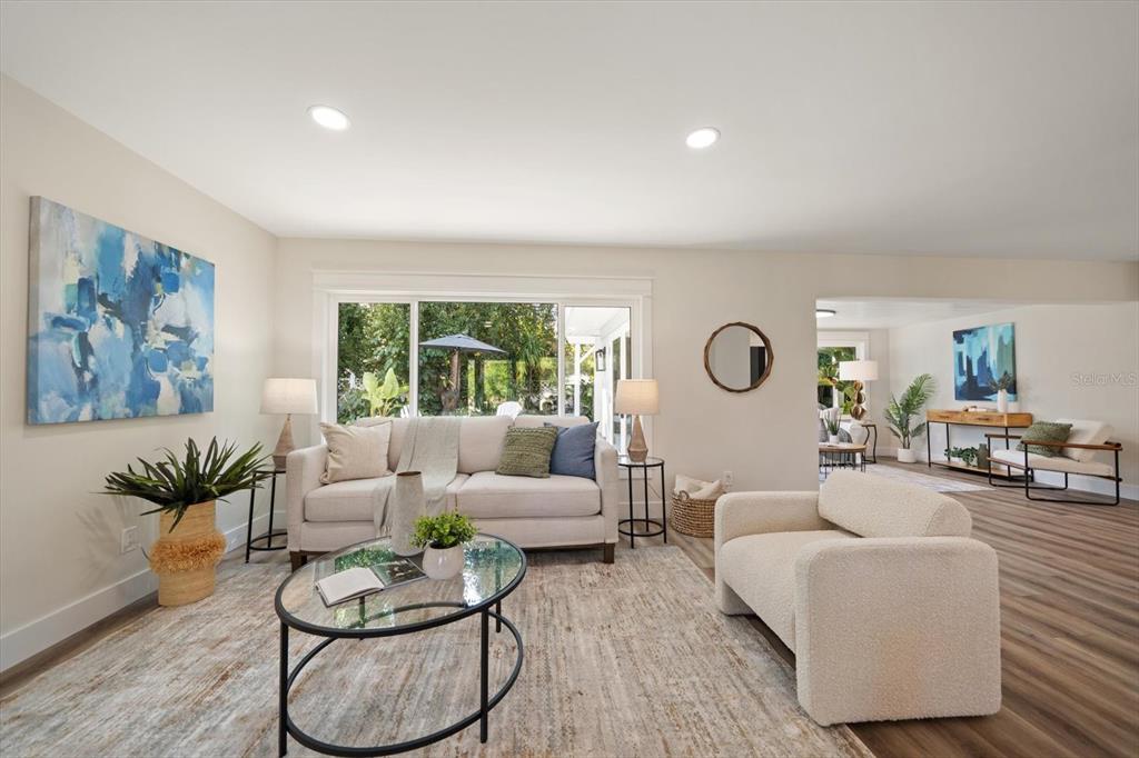 A living room features a beige sofa, a cream armchair, and a glass coffee table — 503 POINSETTIA ROAD, BELLEAIR, FL