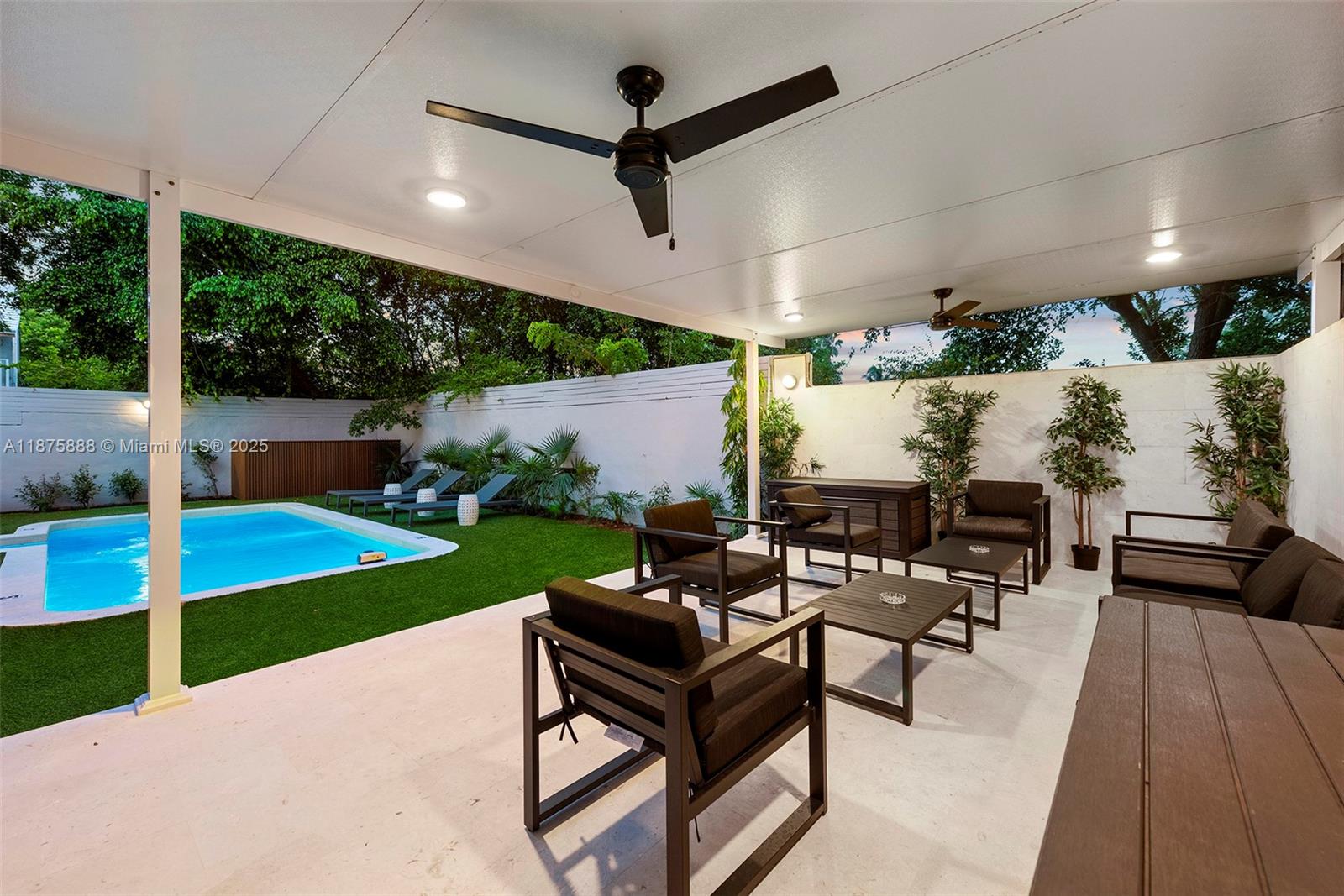 A covered patio features outdoor furniture, a ceiling fan, and a view of a pool — 1019 NE 87th St, Miami FL 33138, MIAMI, FL