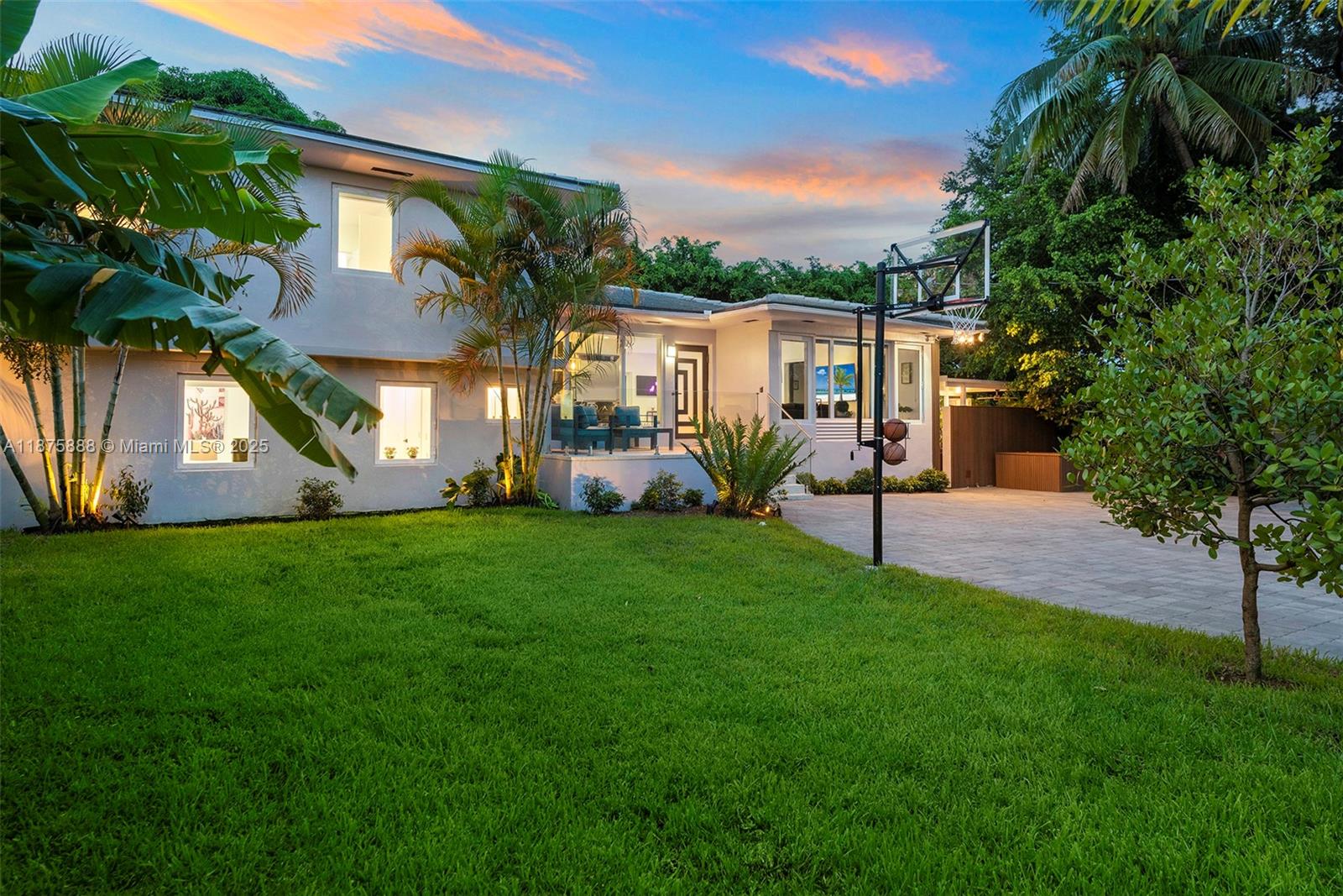 A two-story house exterior features a grassy lawn, a basketball hoop, and a paved driveway — 1019 NE 87th St, Miami FL 33138, MIAMI, FL