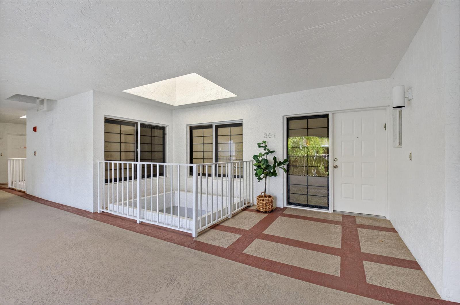 An exterior entryway features a white door, a small fenced courtyard, and a skylight — 7369 Orangewood Lane # 307, Boca Raton FL 33433, BOCA RATON, FL