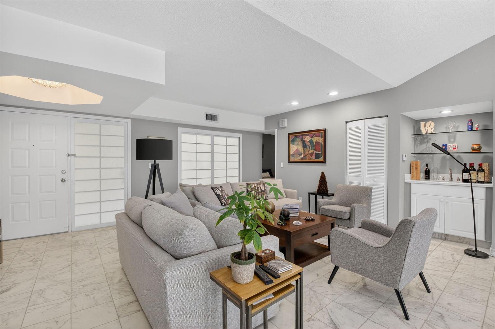 A living room with gray furniture, a wet bar, and marble-style tile flooring — 7369 Orangewood Lane # 307, Boca Raton FL 33433, BOCA RATON, FL