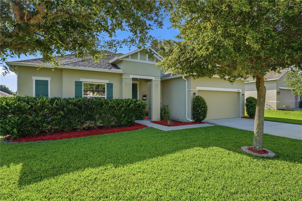 A single-story house with a tan stucco exterior, a two-car garage, and a green lawn — 3629 PELOCK DRIVE, APOPKA, FL