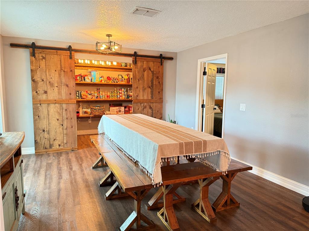 A living room features a wall-mounted television centered between white built-in shelving and cabinets — 10056 GIFFORD STREET, SPRING HILL, FL