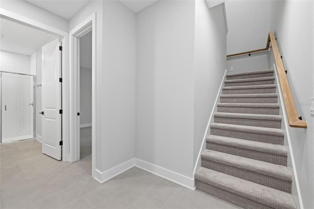 A carpeted staircase leads upward next to a tiled hallway with two open doorways — 4208 W CARMEN STREET UNIT C, TAMPA, FL