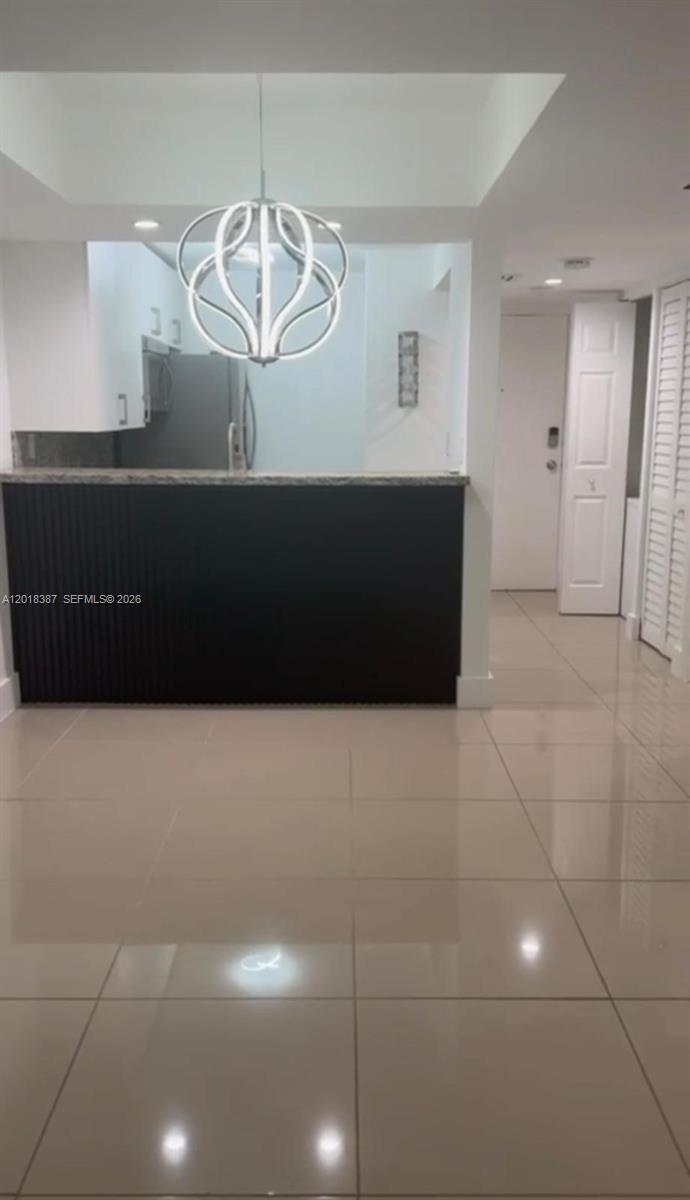 A kitchen with a dark slatted breakfast bar and a modern spherical pendant light — 8004 SW 149th Ave # C418, Miami FL 33193, MIAMI, FL