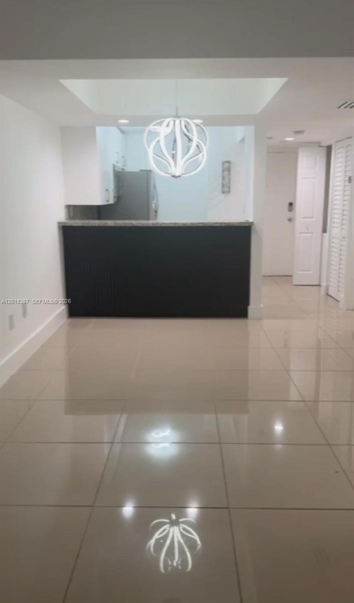 A kitchen with a dark breakfast bar, white cabinets, and a modern pendant light fixture — 8004 SW 149th Ave # C418, Miami FL 33193, MIAMI, FL