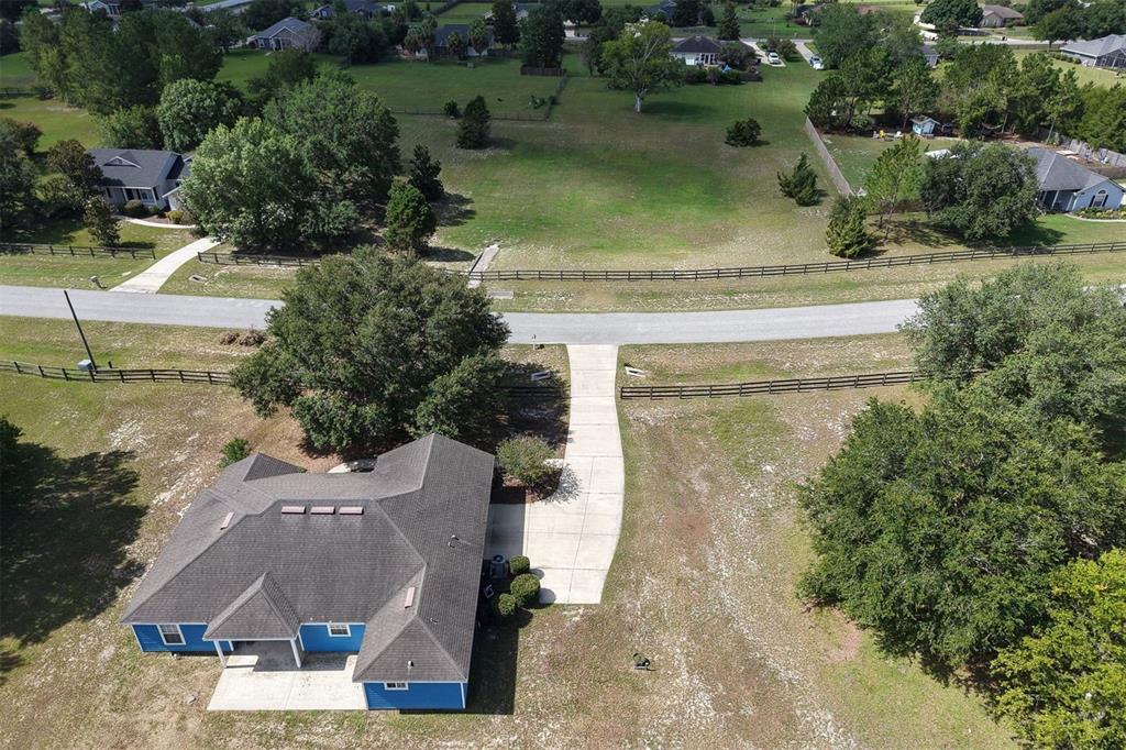 An aerial view shows a single-story house on a large, grassy lot with trees — 9892 SW 95TH PLACE, GAINESVILLE, FL
