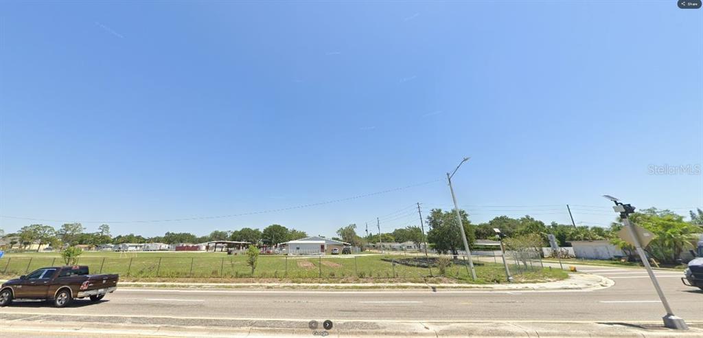 A brown pickup truck is parked on a road in front of a vacant lot — HWY 630 E, LAKE WALES, FL