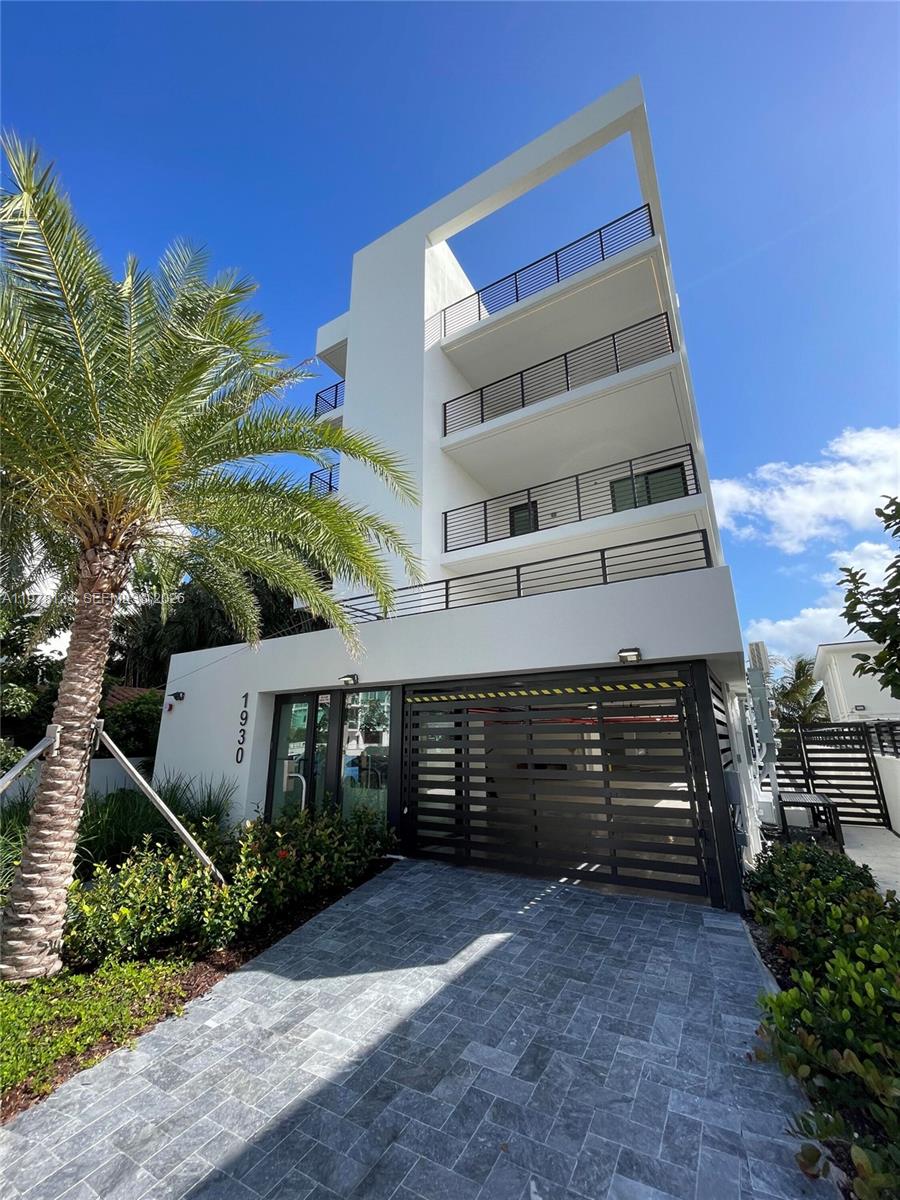 A modern white multi-story building features balconies with black railings and a gated driveway entrance — 1930 Bay Dr # 4, Miami Beach FL 33141, MIAMI BEACH, FL