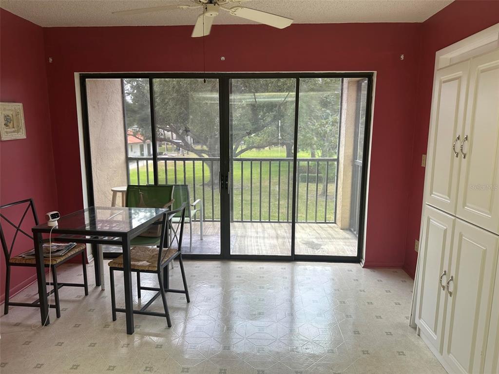 A dining area features red walls, a glass-top table, white cabinets, and sliding glass doors — 5090 BAY STREET NE UNIT 220, ST PETERSBURG, FL