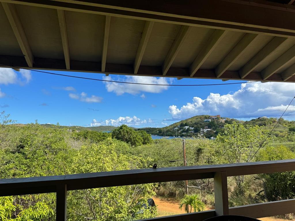 A view of a bay and hills from a covered wooden balcony — 4 BARRIO PLAYA SARDINAS, CULEBRA, PR