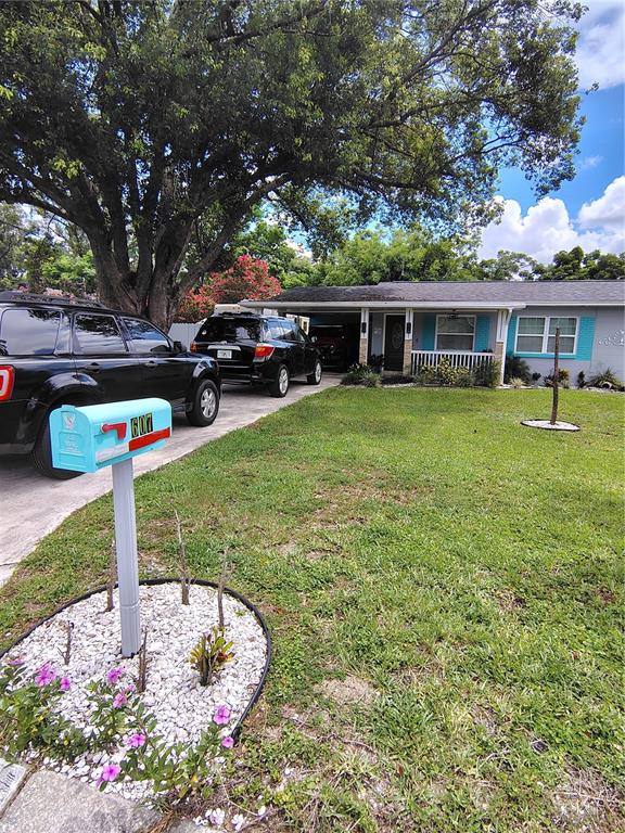 A light blue mailbox stands in the foreground of a single-story house with two parked SUVs — 607 OAK RIDGE DRIVE, BRANDON, FL