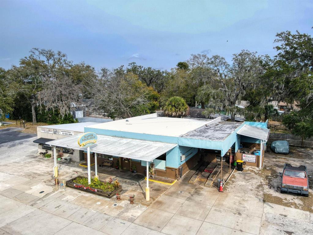 An aerial view shows a light blue commercial auto repair shop with a metal awning — 6118 GRAND BOULEVARD, NEW PORT RICHEY, FL