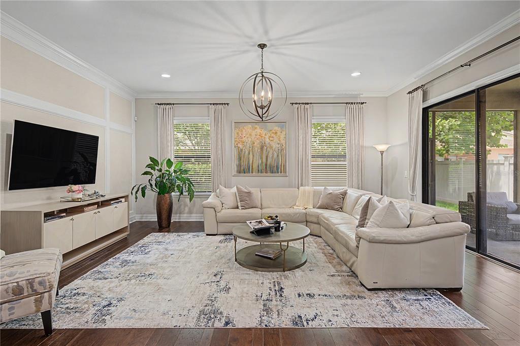 A living room features a large sectional sofa, a round coffee table, and a television — 14317 AVON FARMS DRIVE, TAMPA, FL